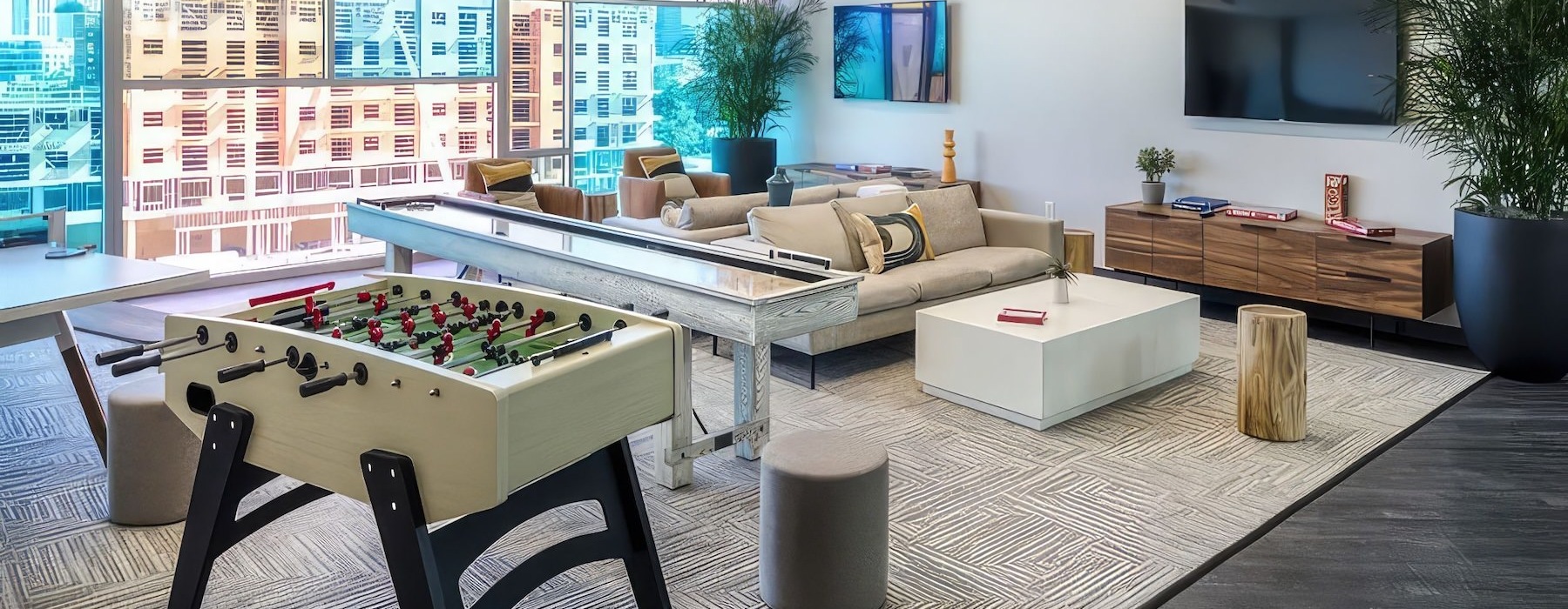 a clubroom with a foosball table, tv and couch