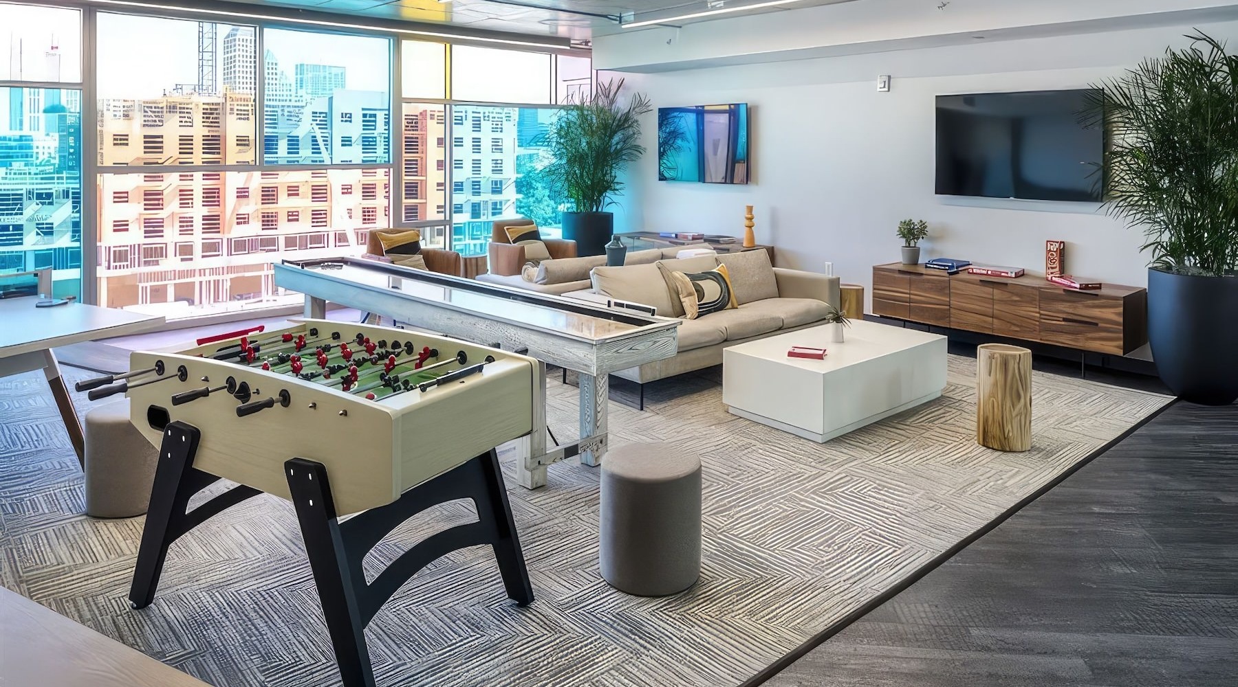 a clubroom with a foosball table, tv and couch